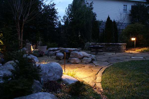 Outdoor lighting guides you safetly over the flagstone to the firepit area.