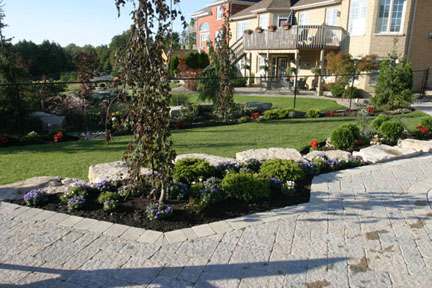 Large natural stones support the garden beds as they transition into the raised patio.